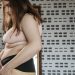Confident young woman measures her hips in a stylish interior, embracing body positivity.