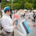 Woman enjoying a parade in Estonia, waving the Estonian flag amidst a lively crowd.
